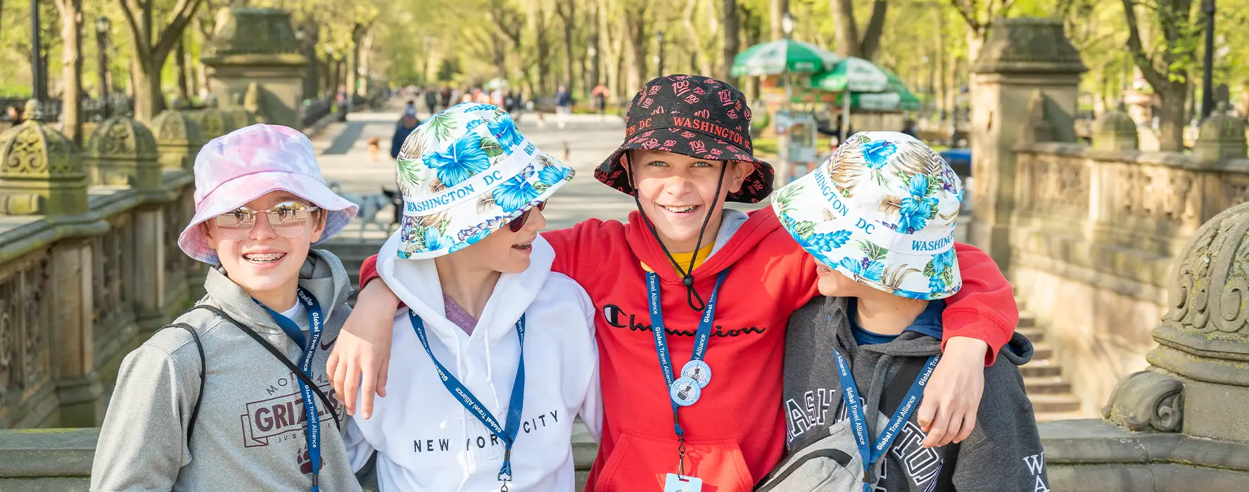 A group of 4 students posing for a photo in a park in New York City.